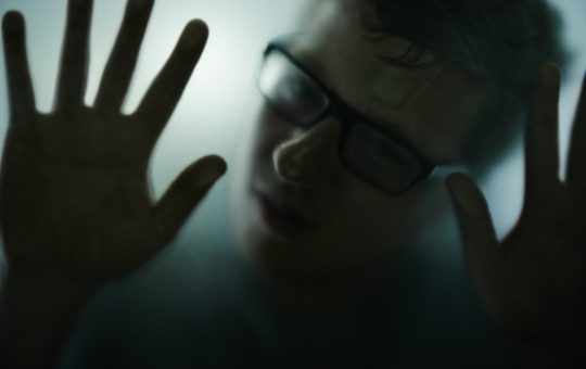 Dont leave me alone in here...Cropped shot of a man behind a glass window during isolation.